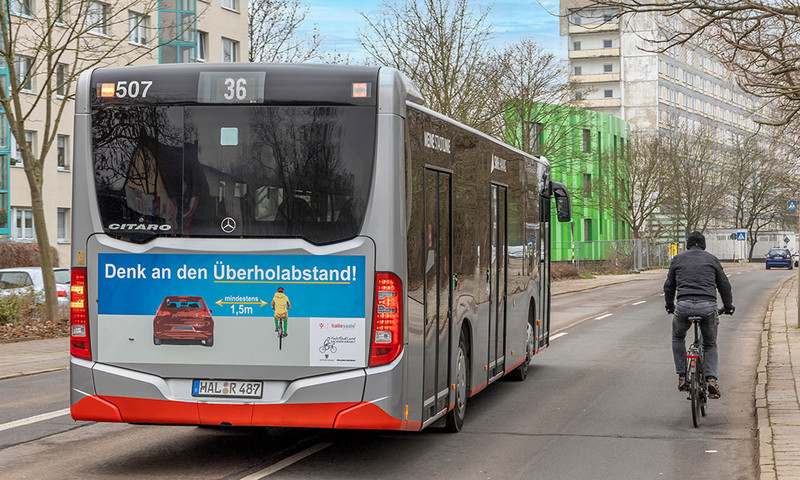 Ein Bus überholt ein Fahrrad im innerstädtischen Verkehr. 